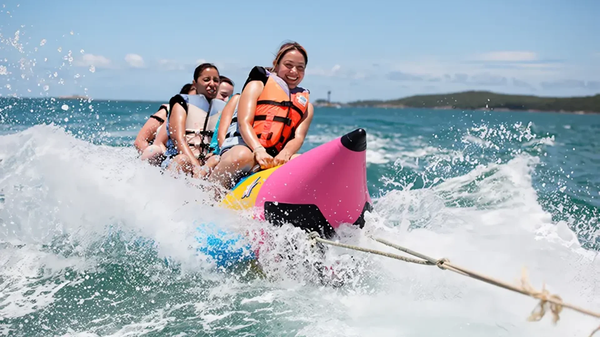 A male surfer expertly riding inside a large, blue wave during a surfing session in Sanur, Bali